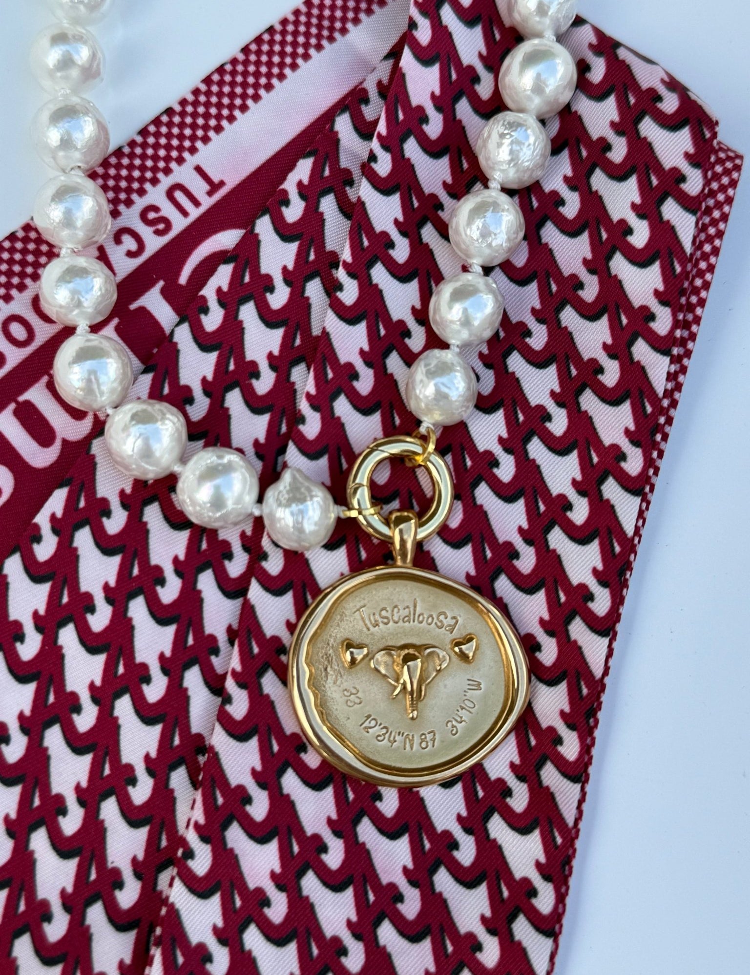 Tuscaloosa Necklace with a gold medallion engraved Tuscaloosa, Alabama and its coordinates