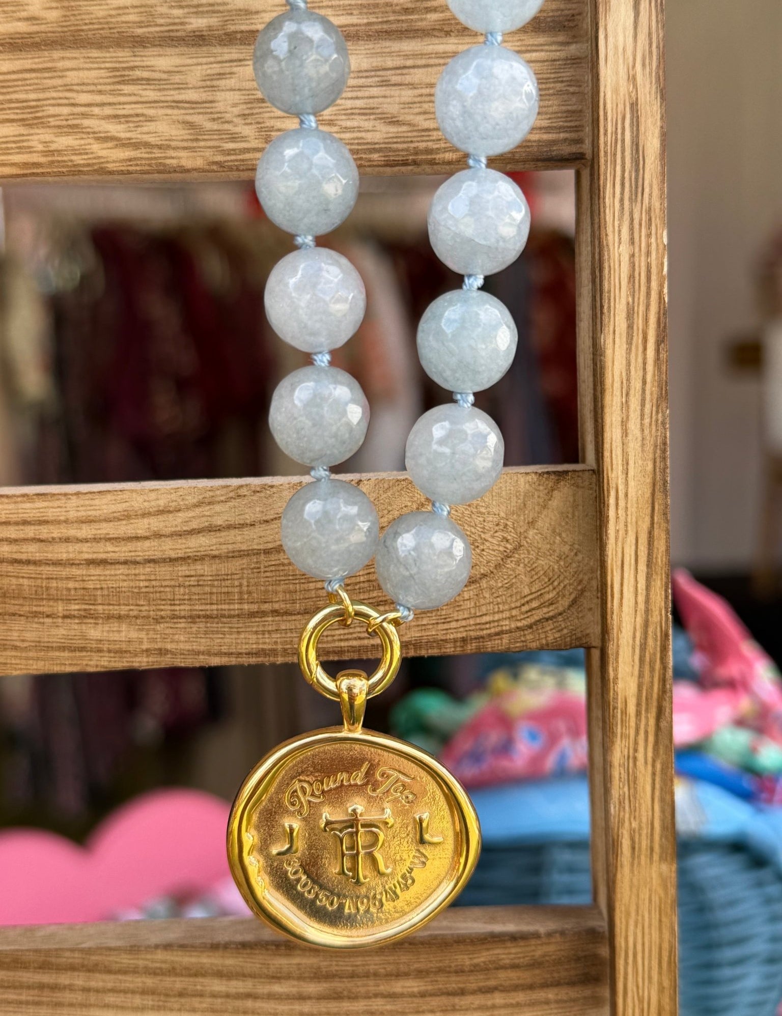 Round Top Necklace with a gold crest medallion, alternate view