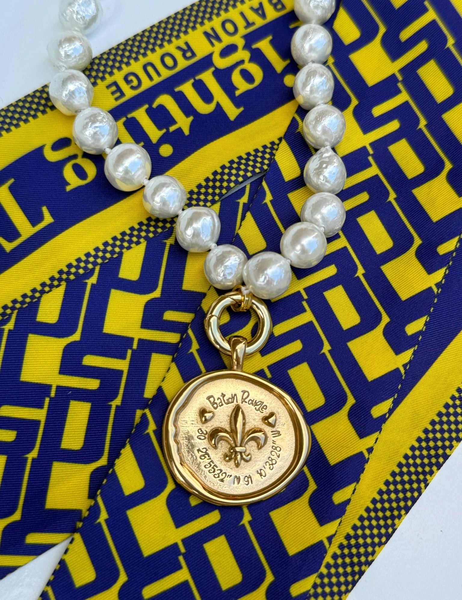 Baton Rouge Necklace with a gold fleur-de-lis medallion and Baton Rouge coordinates, alternate view