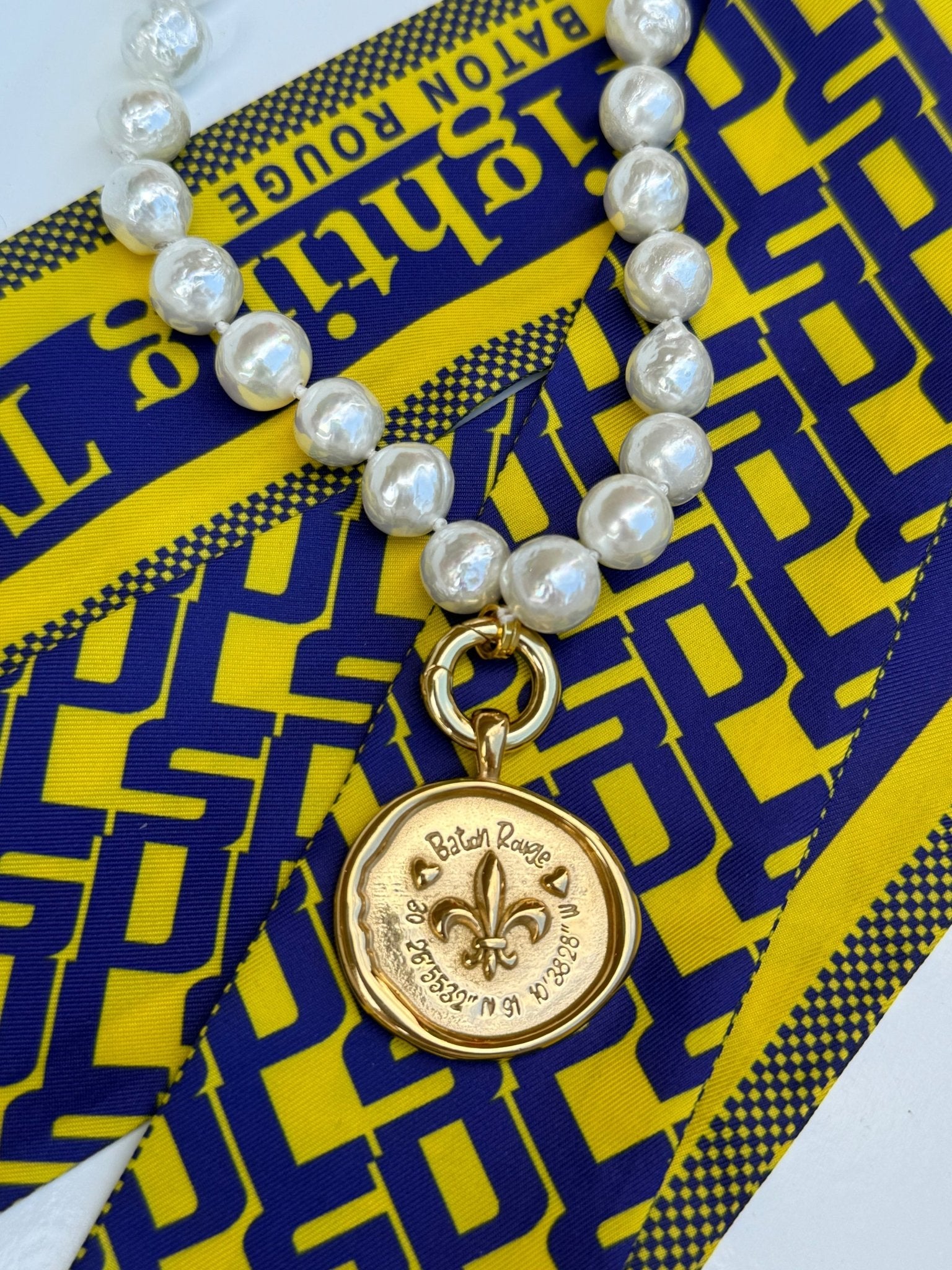 Baton Rouge Necklace with a gold fleur-de-lis medallion and Baton Rouge coordinates, alternate view