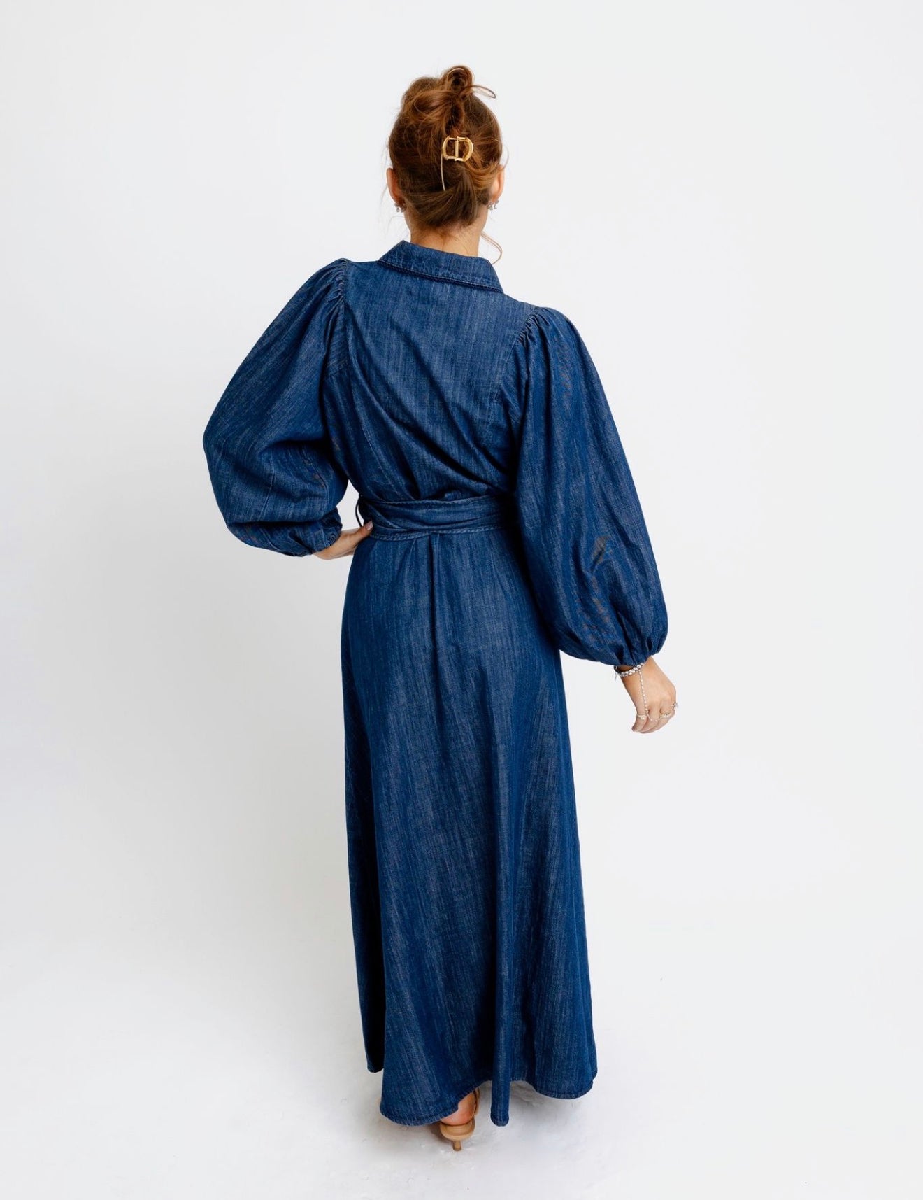 Back view of the Denim Puff Sleeve Dress, a dark-wash belted denim maxi