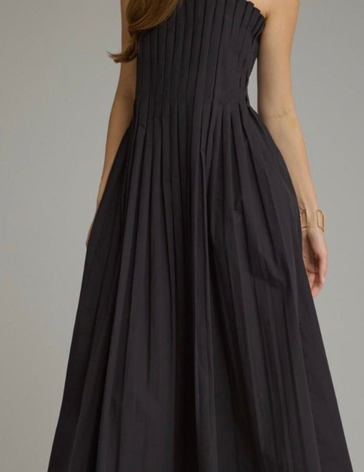 Back view of the Sawyer Dress, a black pleated square-neck midi