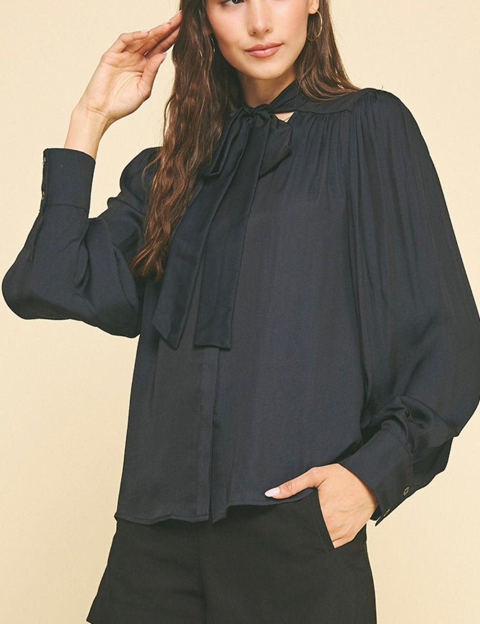 Back view of the Black Tie Neck Top, a black tie-neck button-down blouse