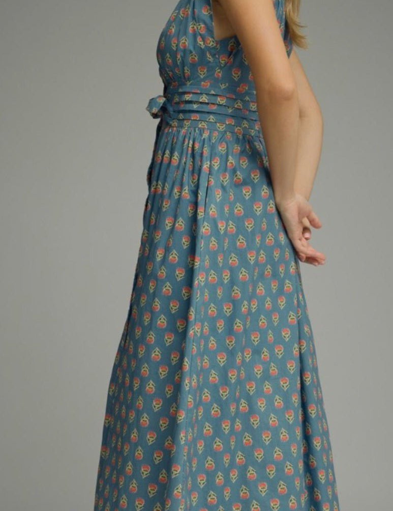 Back view of the Patterned Poppy Dress, a blue floral midi with flutter sleeves