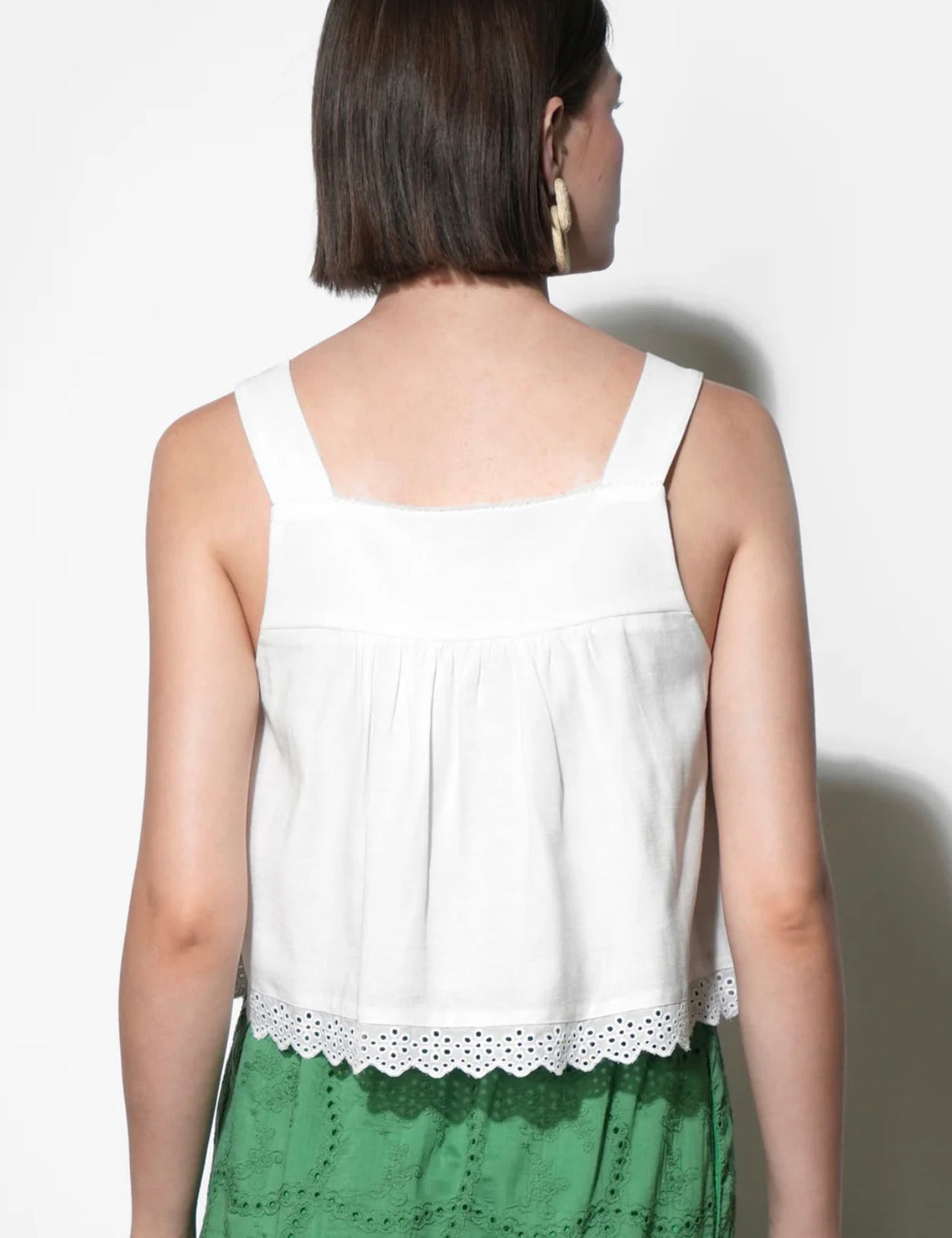 Close-up of the pintucks and scalloped eyelet hem on the Elani Eyelet Tank Top