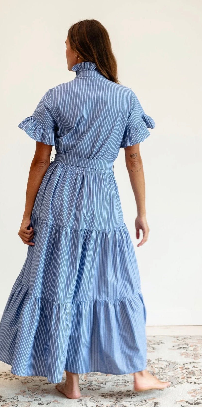 Close-up of the tiered skirt and stripe pattern on the Harbor Stripe Maxi Dress