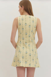 Back view of the Lemon Yellow Floral Dress, a pastel yellow dress with blue floral sprigs