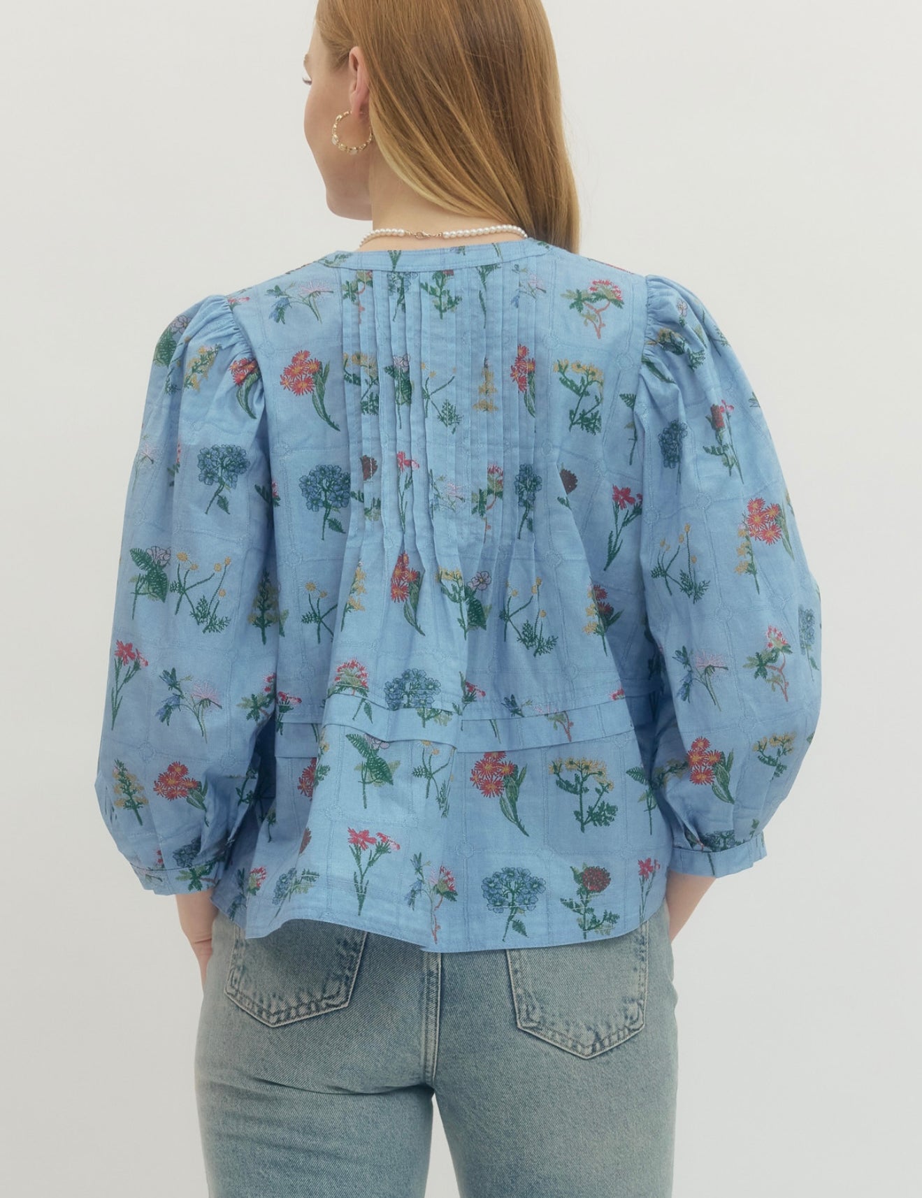 Back view of the Chambray Floral Top, a soft blue floral empire waist blouse – Lady & Tucker
