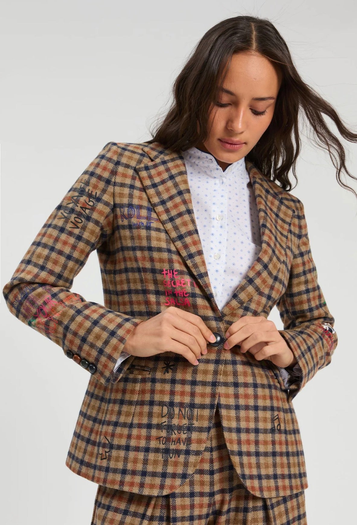 Graffiti Plaid Jacket, a tan plaid blazer with embroidered phrases, worn front view