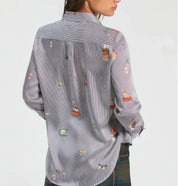 Close-up of the travel-inspired embroideries on the Hotel Striped Shirt – Lady & Tucker